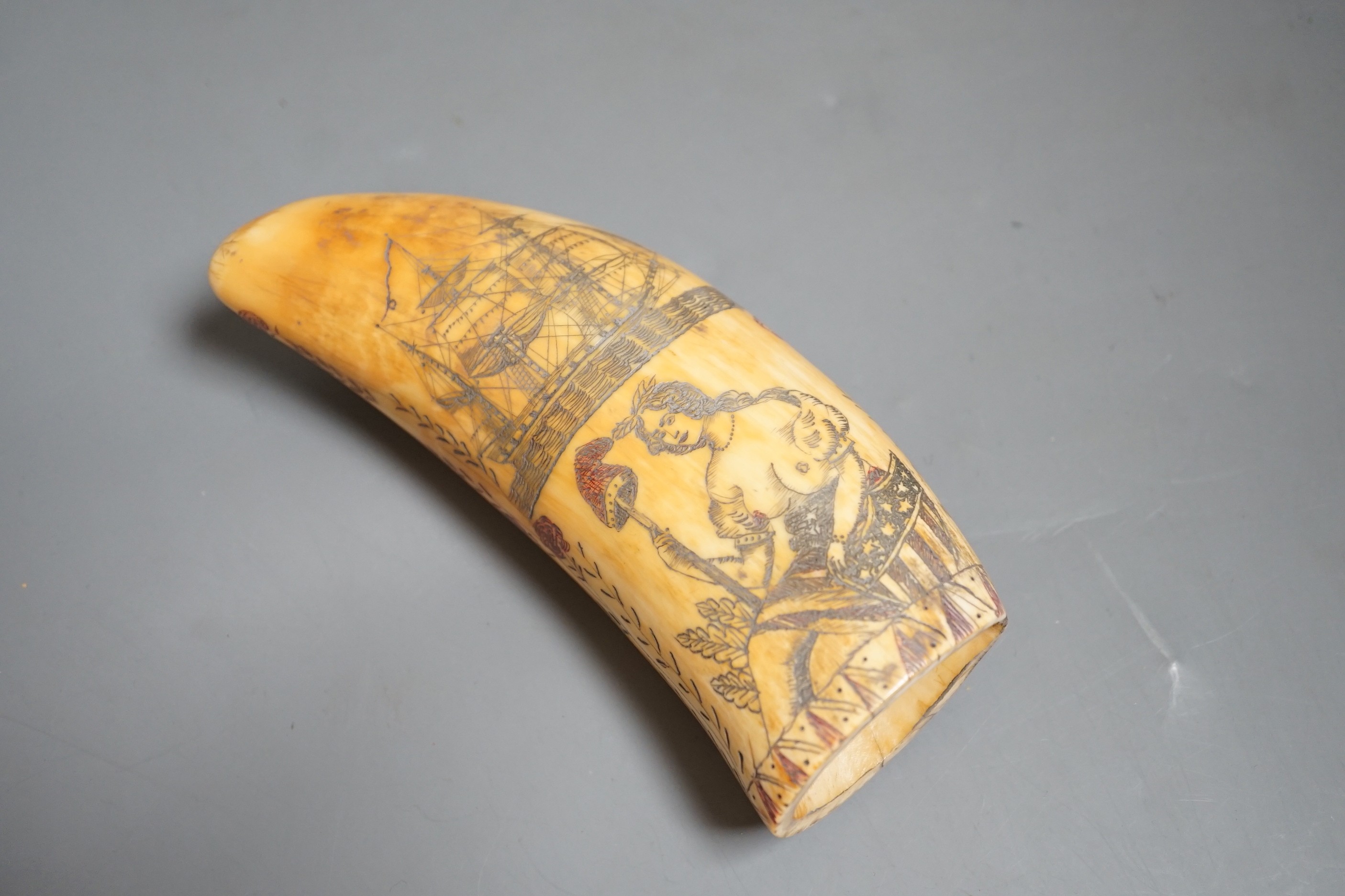 A 19th century scrimshaw erotic carved sperm whale tooth, 14cm long.